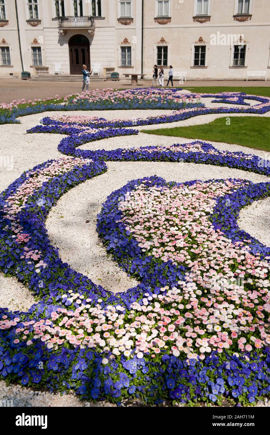 Gänseblümchen und Stiefmütterchen Blumen im Frühling, Blick auf die ornamentale Barockgarten in radziwiłł's Palace in Nieborów Exterieur in Polen, in Europa. Stockfoto