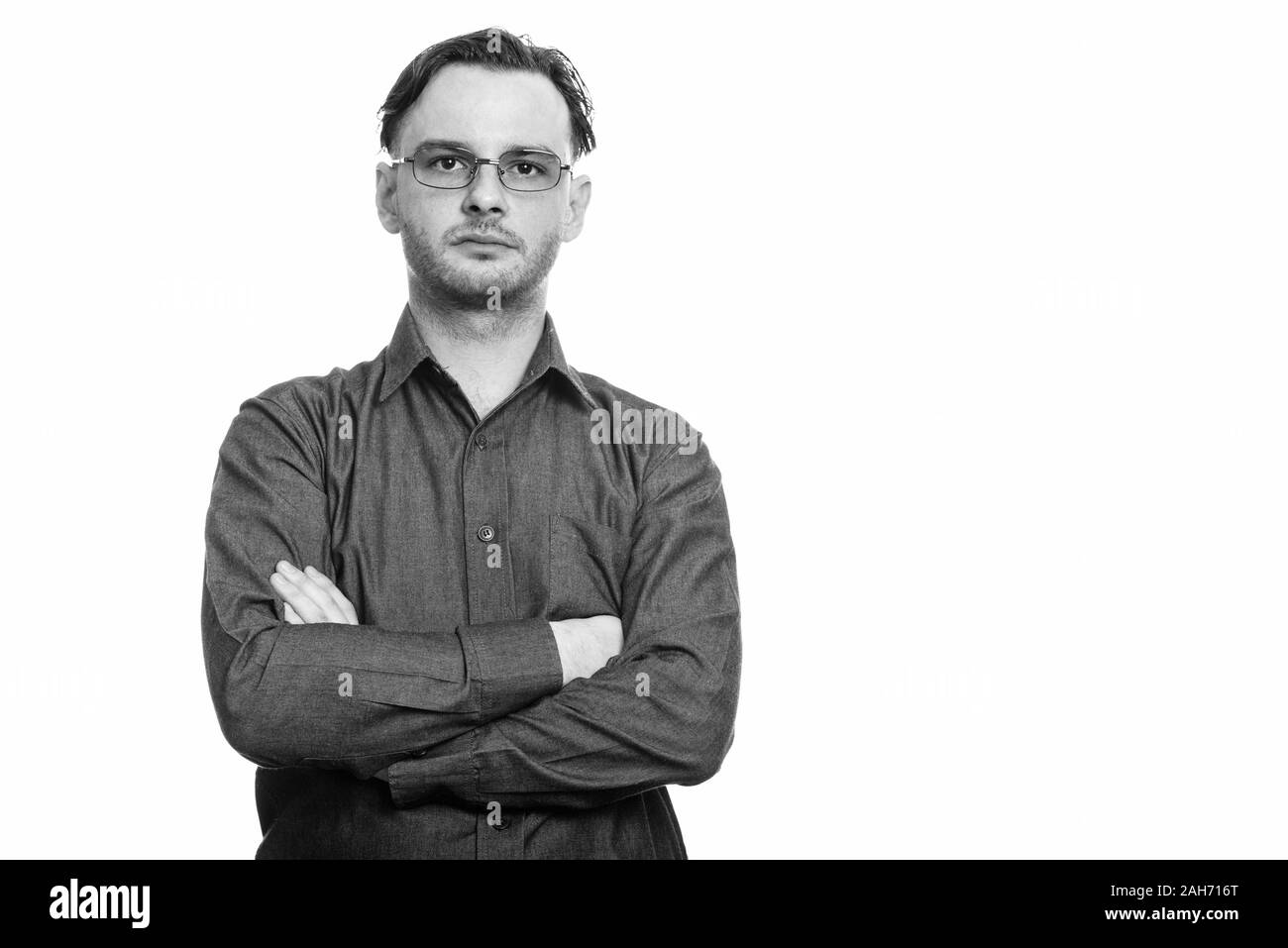 Studio shot der formalen junger Mann Brille tragen mit gekreuzten Armen Stockfoto