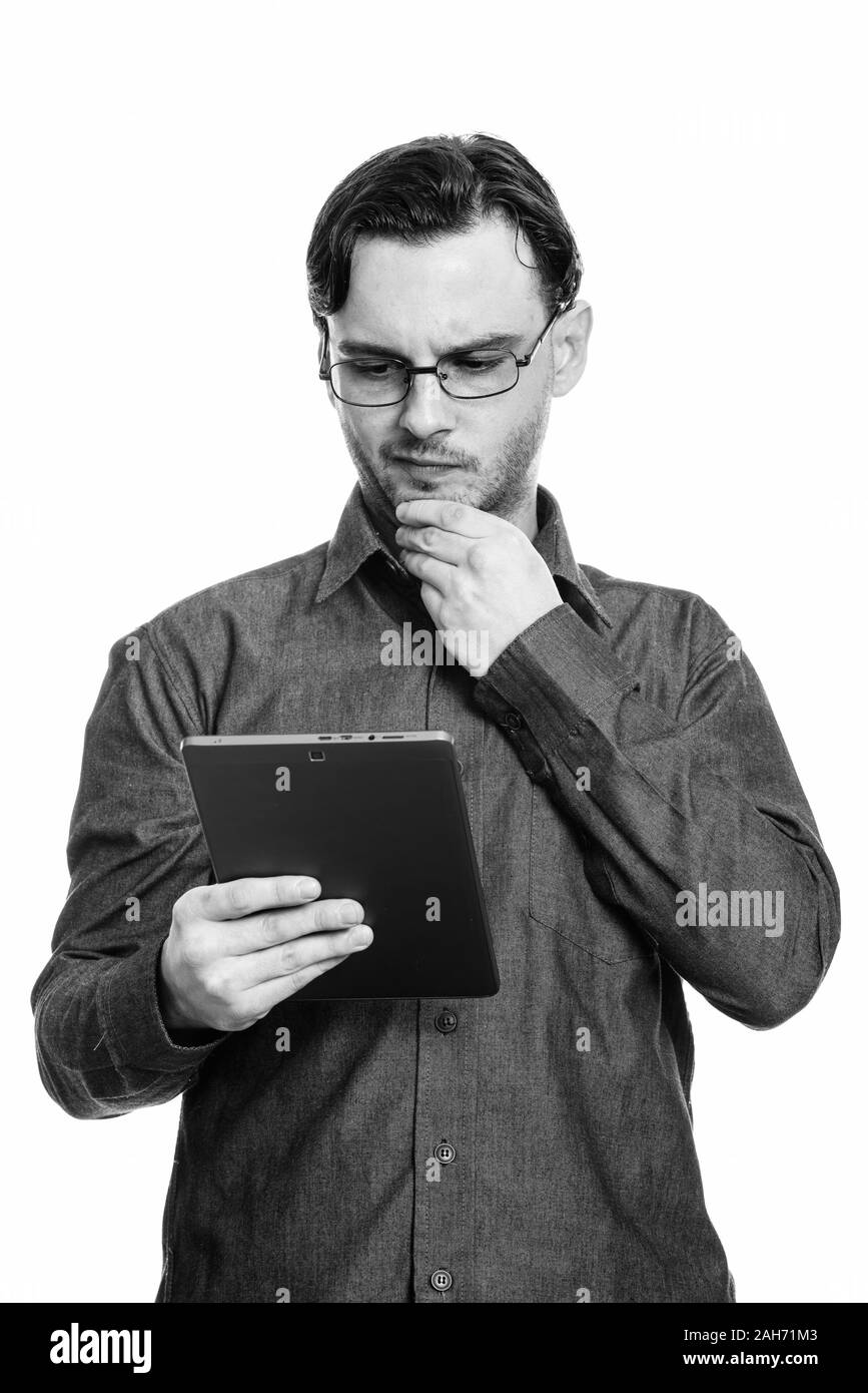 Studio shot der formalen jungen Mann mit digitalen Tablet beim Denken Stockfoto