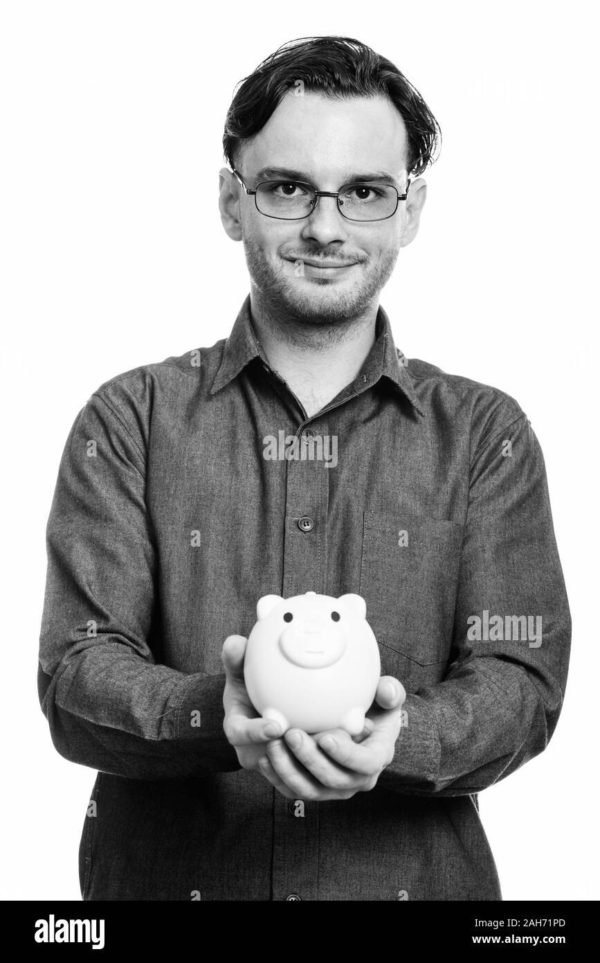 Studio shot der formalen junge Mann hält piggy Bank Stockfoto