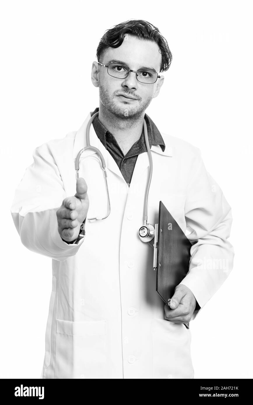 Studio erschossen der junge Mann Arzt holding Zwischenablage und Handshake Stockfoto
