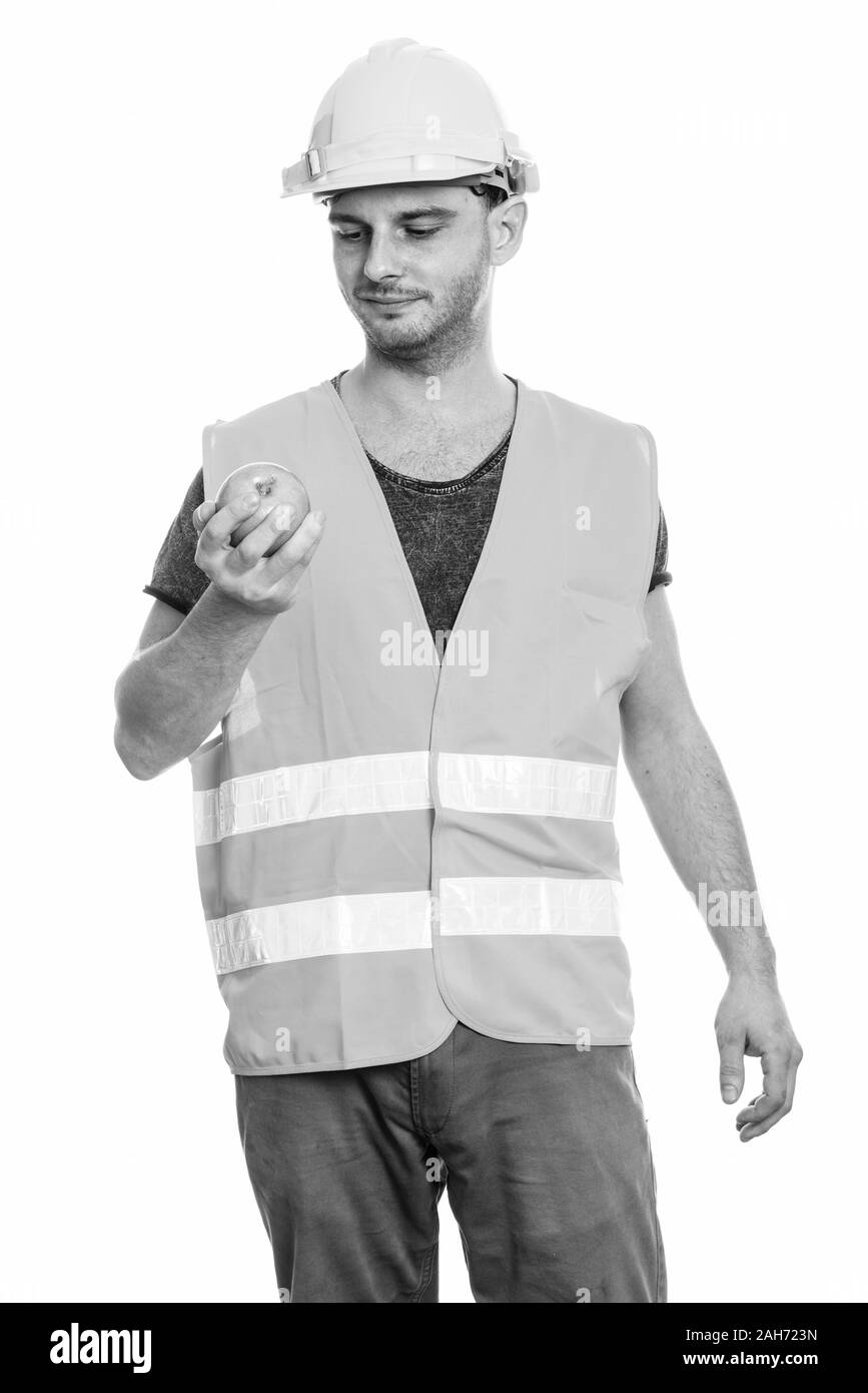 Studio shot des jungen Mannes Bauarbeiter Holding und im Green Apple suchen Stockfoto