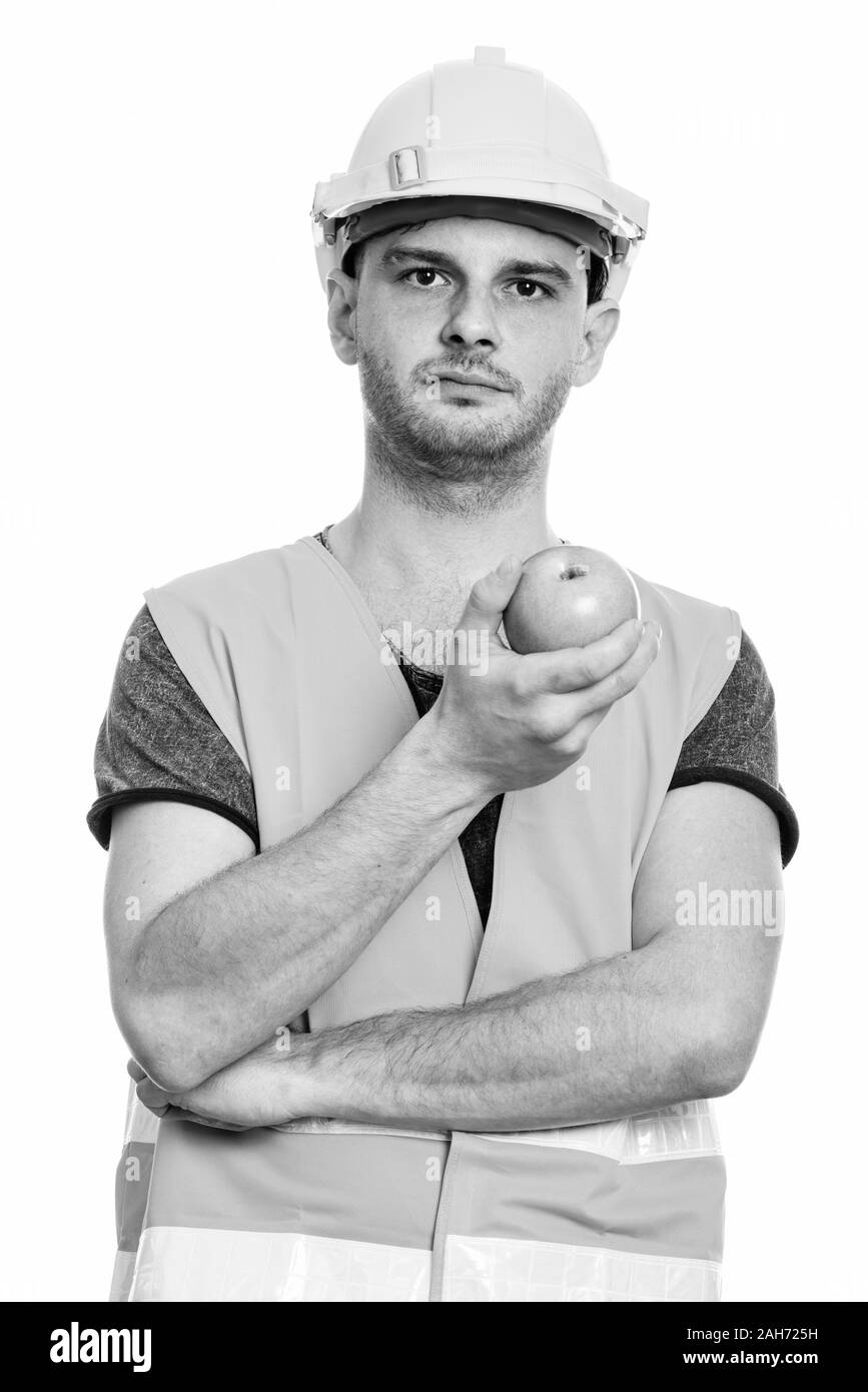 Der junge Mann Bauarbeiter holding Green Apple Stockfoto