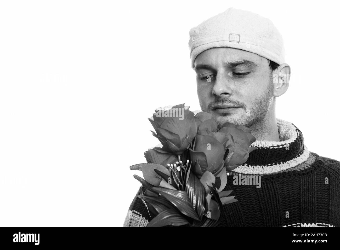 Studio shot junger Mann hält und rote Rosen Stockfoto