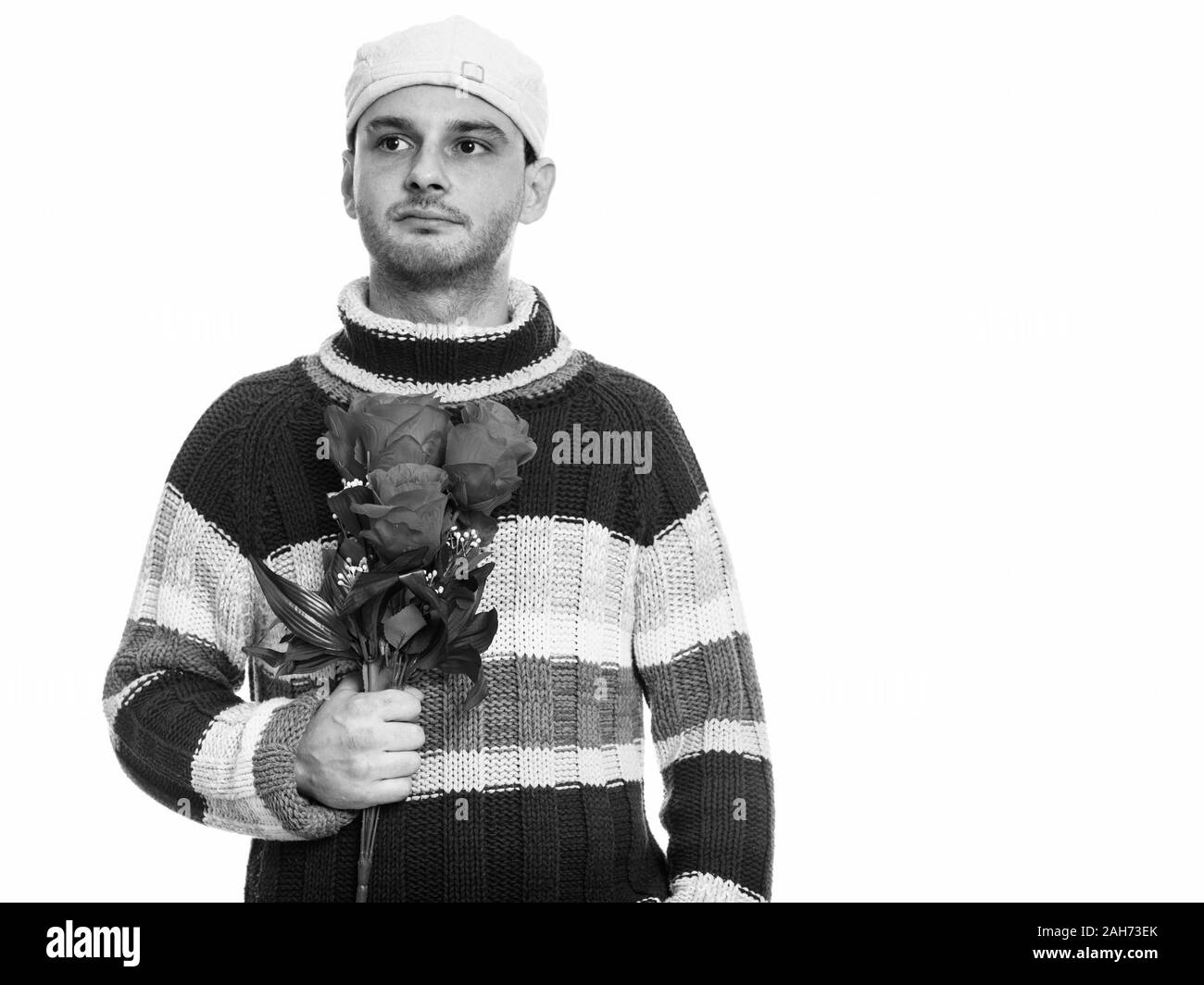 Studio shot junger Mann mit roten Rosen, beim Denken Stockfoto