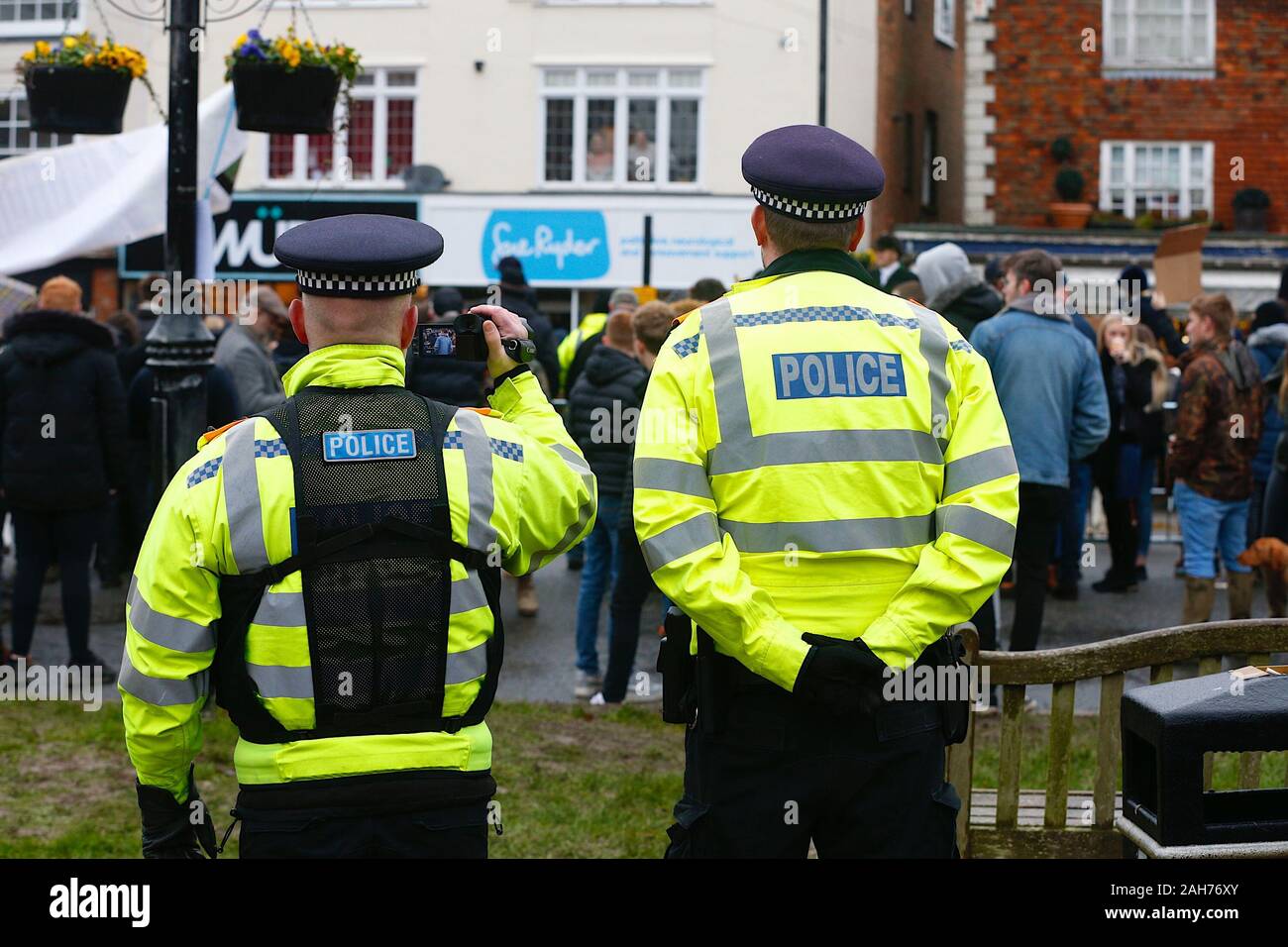 Tenterden, Kent, Großbritannien. Dezember 2019. Das jährliche Treffen am Boxing Day der Ashford Valley Tickham Hunt findet im Zentrum von Tenterden in Kent statt. Hunde und Pferde versammeln sich um 11 Uhr im Pub "The Vine Inn", bevor sie die hohe Straße zu einem vollen Publikum hinunterfahren. Das Wetter ist nass mit regnerischen Regenfällen. Polizeibeamte beobachten mit Videoüberwachung HIS Jacken und nehmen die Menge auf. ©Paul Lawrenson 2019, Photo Credit: Paul Lawrenson/Alamy Live News Stockfoto