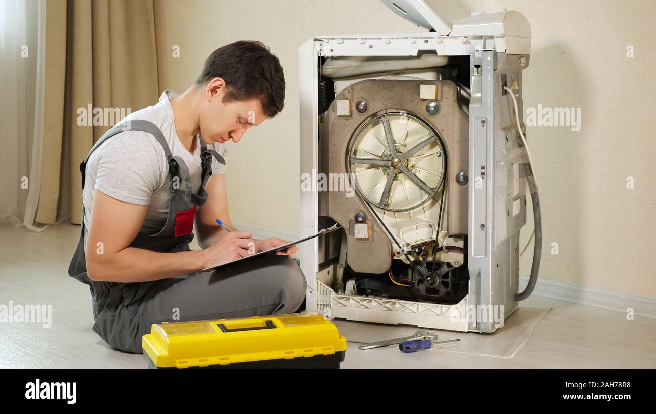 Junge Offiziere Uberpruft Defekte Waschmaschine Frontlader Mit Offener Ruckseite Panel Auf Dem Boden Im Zimmer Ansicht Schliessen Stockfotografie Alamy