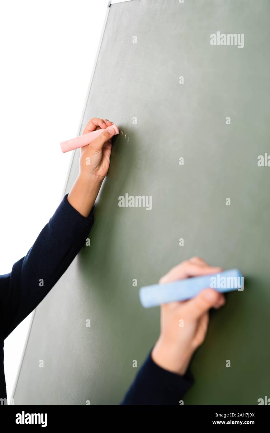 7/8-Ansicht von zwei multikulturelle Schülerinnen schreiben auf der Schiefertafel isoliert auf weißem Stockfoto