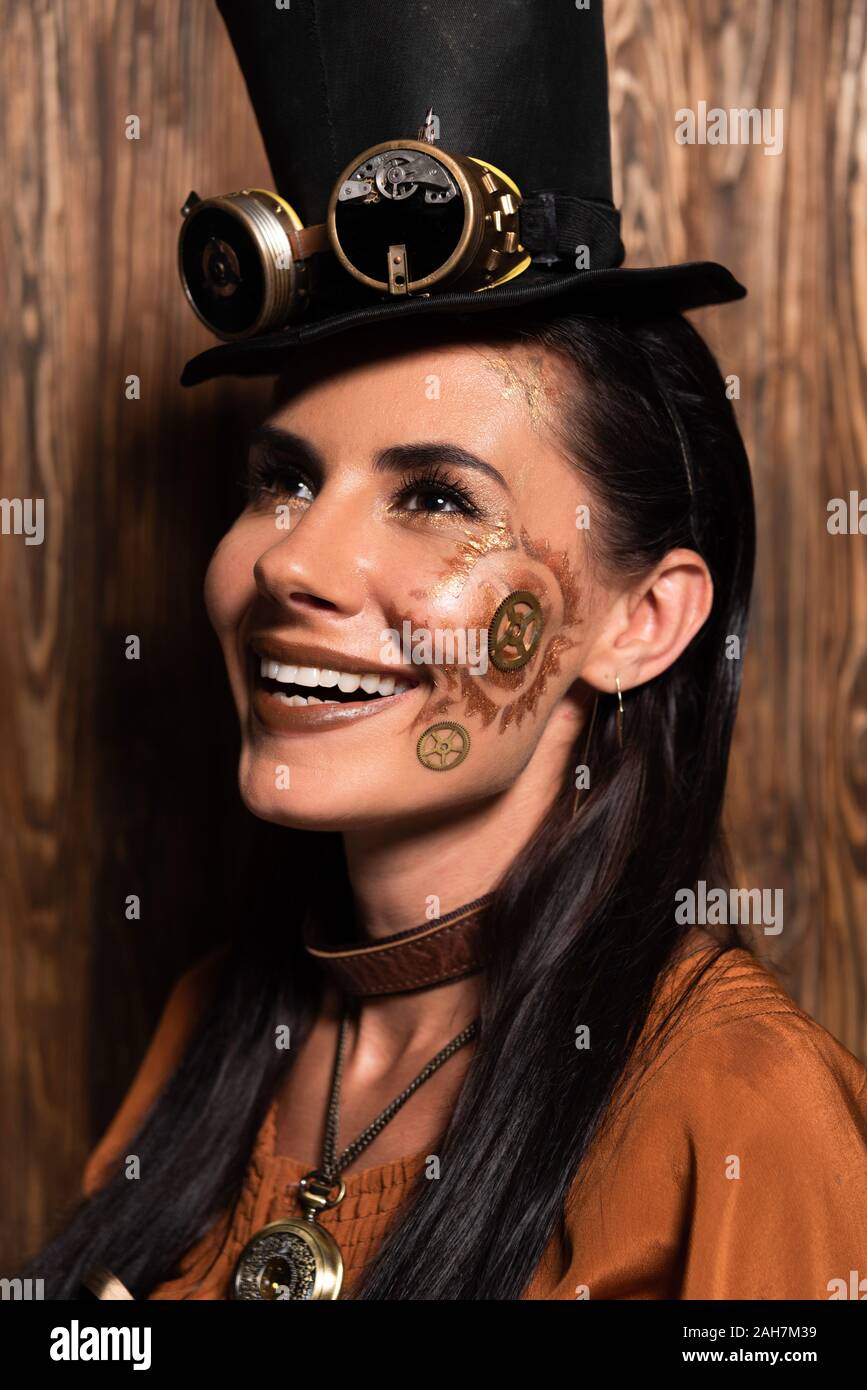 Fröhliche steampunk Frau mit Make-up suchen und lächelnd auf Holz Stockfoto