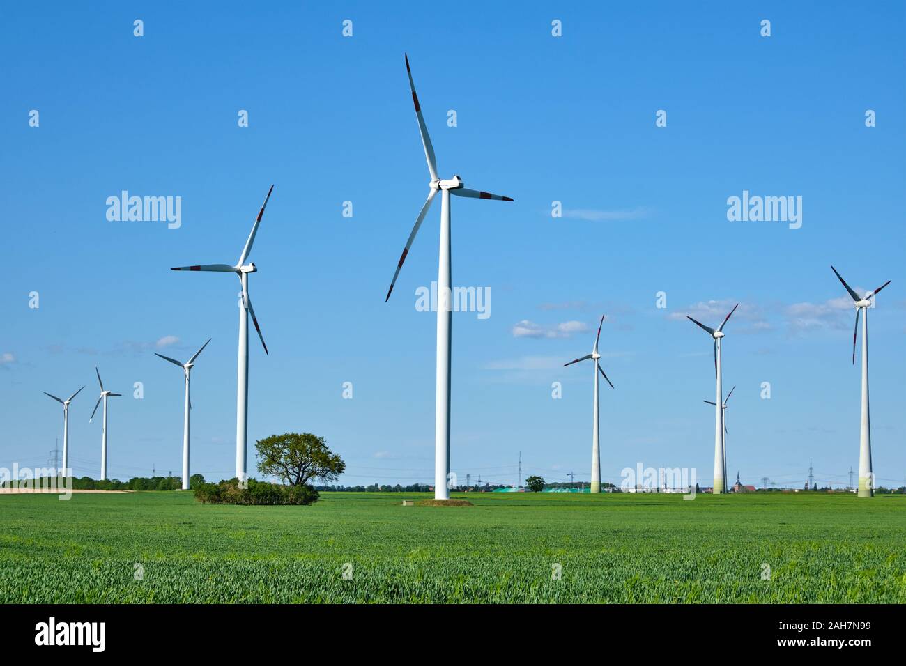 Moderne Windenergieanlagen in einem in Deutschland gesehenen Kornfeld Stockfoto