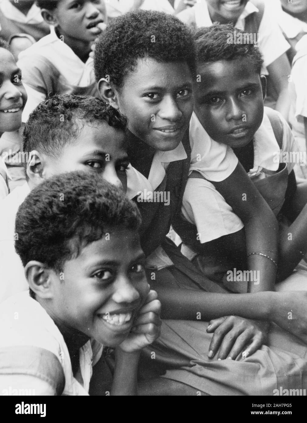 Fiji, Fidschi Mädchen in Uniform. Dieses Porträt erscheint vier Mädchen in einem ähnlichen Alter, möglicherweise Schulkinder zu, alle in Uniform, bestehend aus Bluse und Schürze Kleider gekleidet. Bildunterschrift lautet: eine Mutter mit ihrer kleinen Familie, 1965. 2005/010/1/14/35. Stockfoto