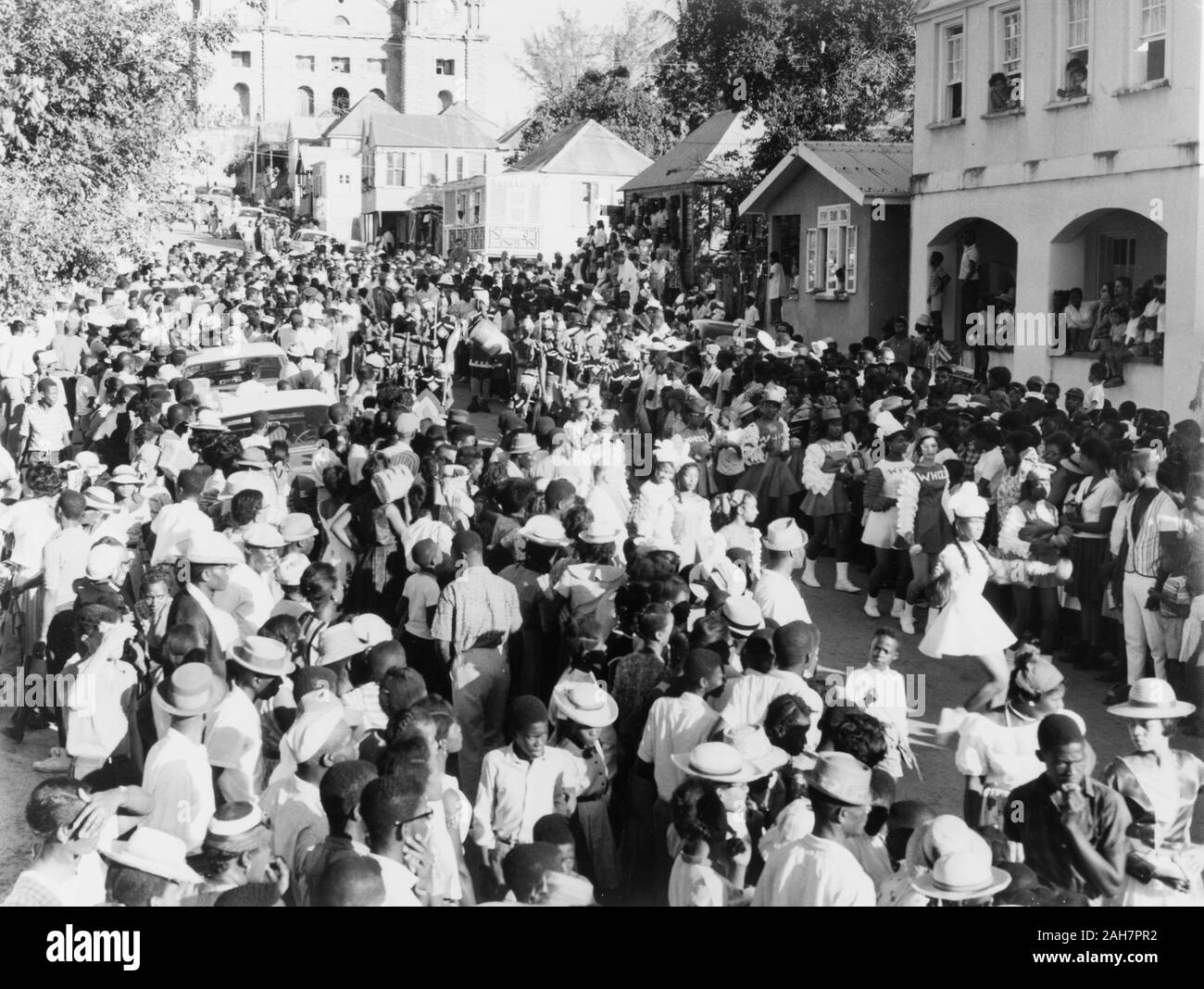 Antigua, Karnevalsumzug in St John's Menschenmassen der Hauptstraße in St John's Pack bei einem faschingszug durch die Innenstadt. Die Kathedrale von St. John's ist nur in der Ferne sichtbar. St. Johns, Antigua, 1965, 1965. 2005/010/1/13/25. Stockfoto