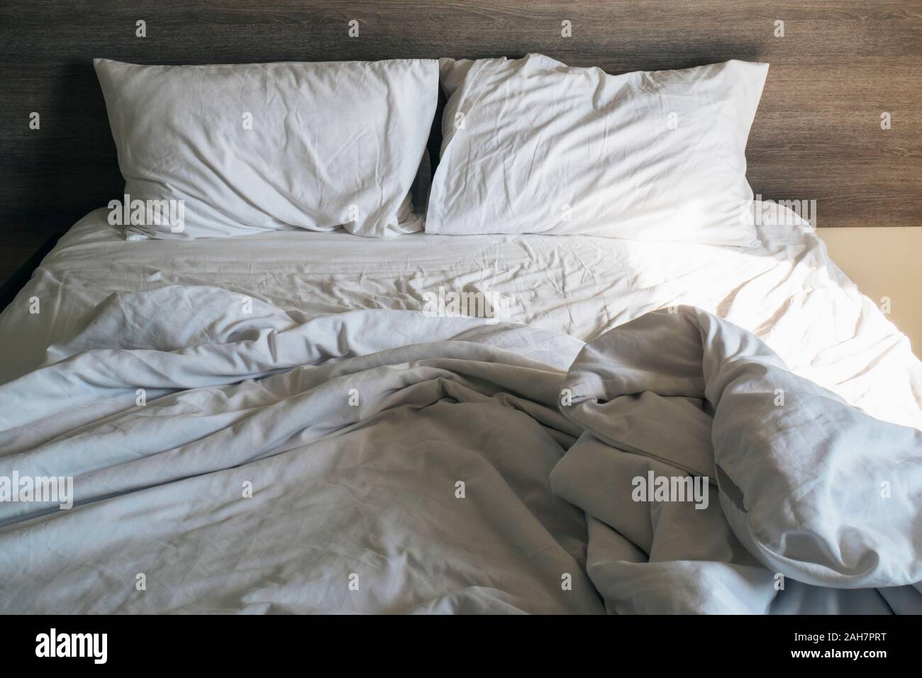 Weiß Kissen und Decke auf dem Bett ungemacht. Unordentliche Bett nach  verwendet. zerknittert weißer Bettwäsche, Kissen und Bettwäsche  Stockfotografie - Alamy