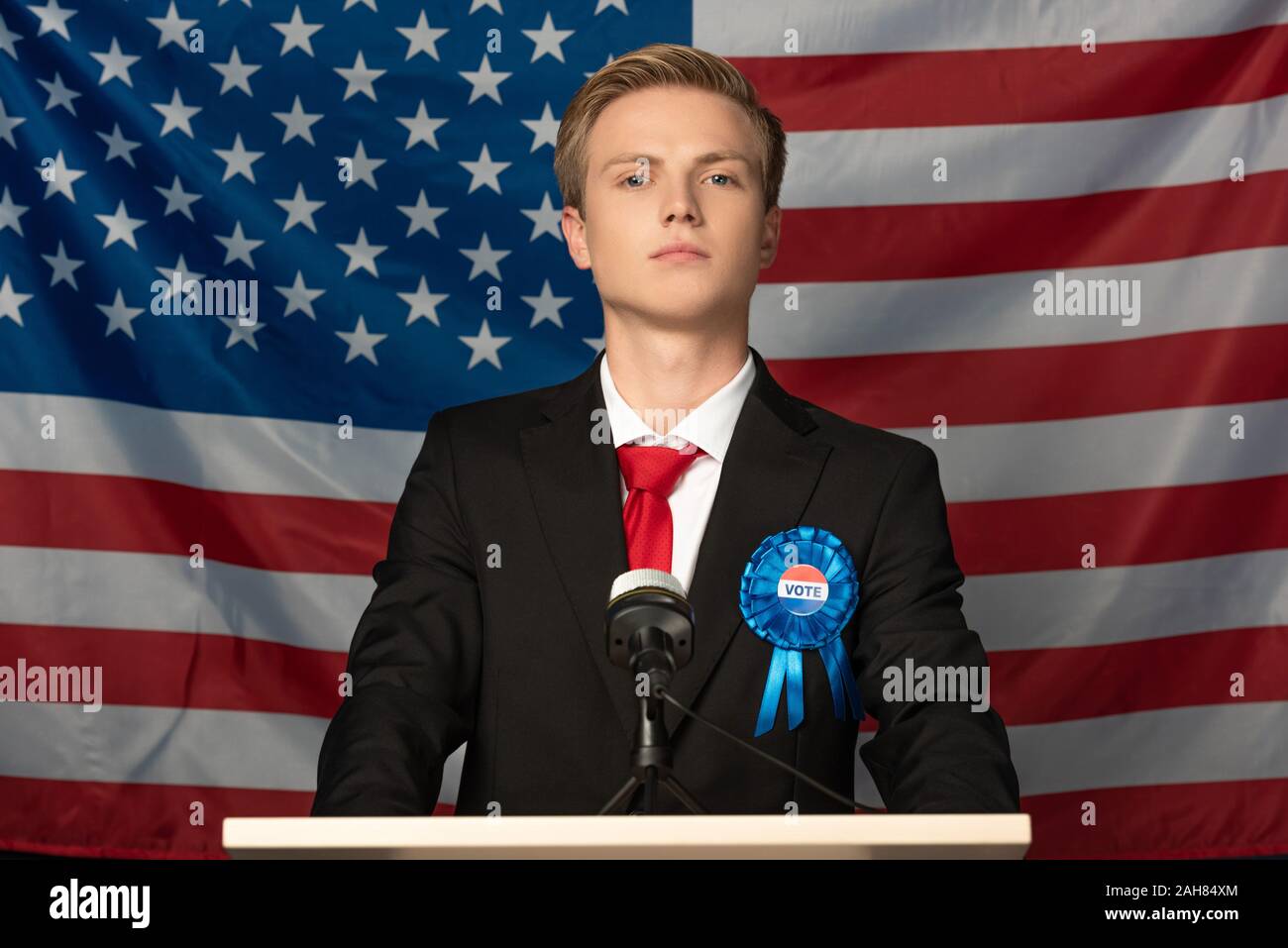 Kiew, Ukraine - Oktober 18, 2019: überzeugte Mensch nachahmen Donald Trump auf der Tribüne auf die amerikanische Flagge im Hintergrund Stockfoto