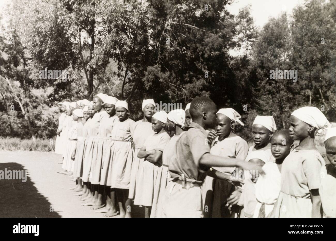 Kenia, Kikuyu-jungen Frauen sind im Freien an der Kirche von Schottland Mission School gesäumt. Originalmanuskript Bildunterschrift: an die Mission der Schule (Kirche von Schottland) die Mädchen sind in europäischen Kleidung & lehrte inländischen Fähigkeiten.S. Nyeri, 1936, 1937. 1995/076/1/2/5/46. Stockfoto