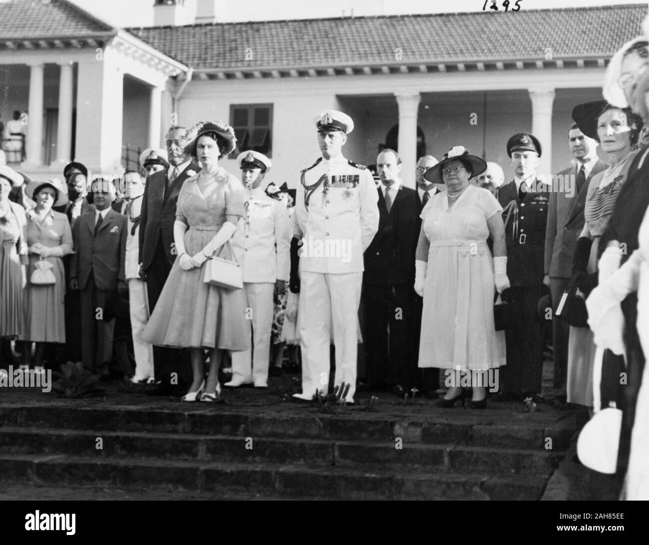 Kenia, Prinzessin Elizabeth und der Herzog von Edinburgh und eine grosse Menge an Zuschauern, darunter Lady Mitchell und drei uniformierte Beamte stand auf der Treppe vor das Government House, Nairobi, Februar 1952. 2001/090/1/4/1/26. Stockfoto