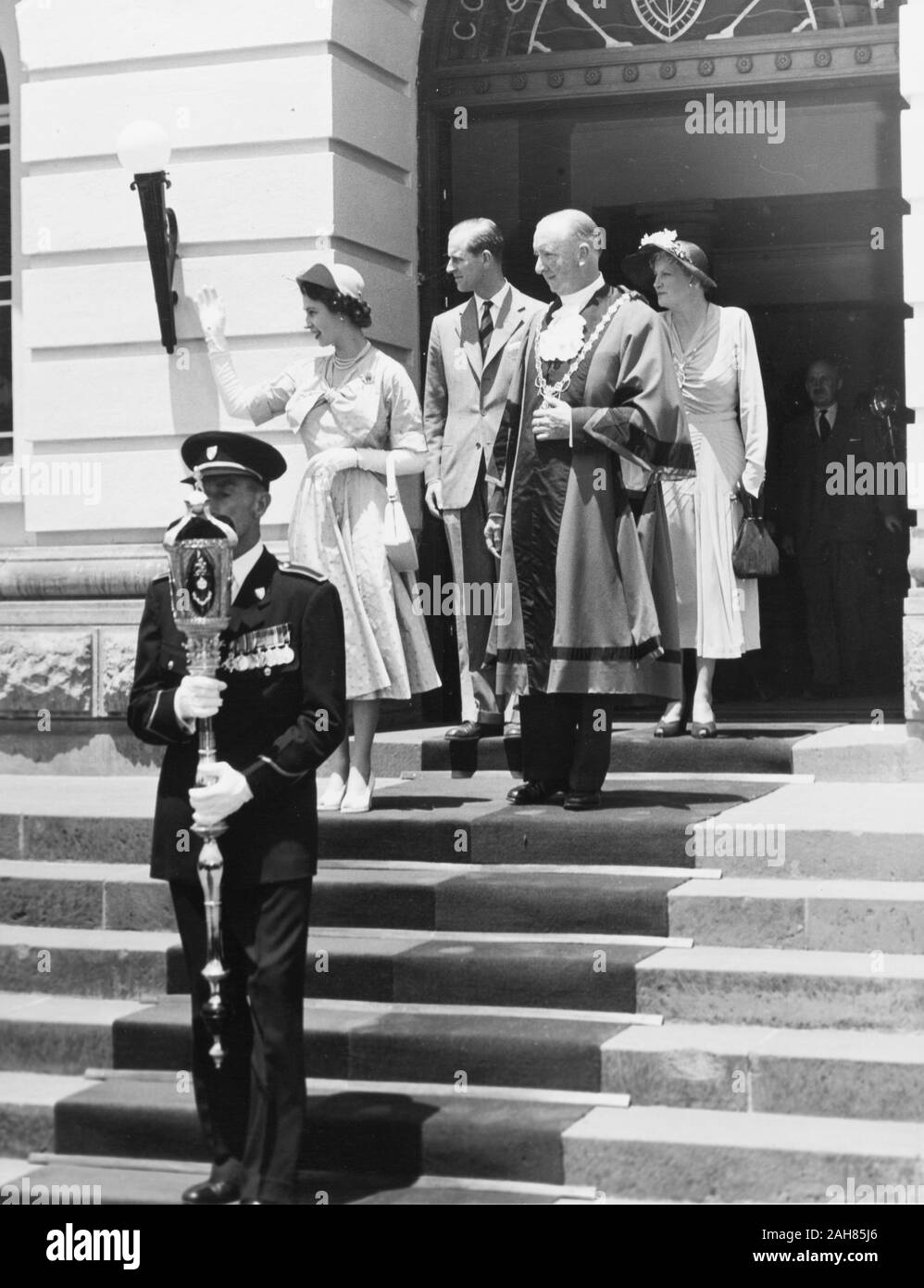 Kenia, Prinzessin Elizabeth und der Herzog von Edinburgh, zusammen mit dem Bürgermeister und Bürgermeisterin von Nairobi, stehen Sie auf den Stufen des Rathauses, als sie sich zum Aufbruch bereit. Die Prinzessin Wellen als die ganze Gruppe schaut zu seiner Rechten. Vor der Gruppe steht eine mace Bearer das Tragen einer Uniform, Februar 1952. 2001/090/1/4/1/65. Stockfoto
