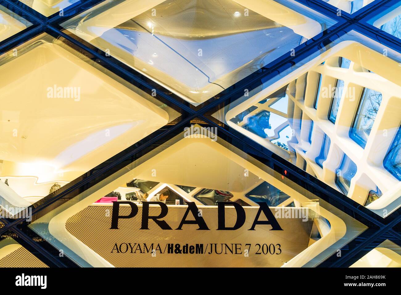 Prada Aoyama store, Tokio. Ein Glas Kristall Gebäude aus Rautenförmigen-Scheiben, beleuchtet, Nacht. Nahaufnahme von Glasscheiben mit Prada-Logo. Stockfoto