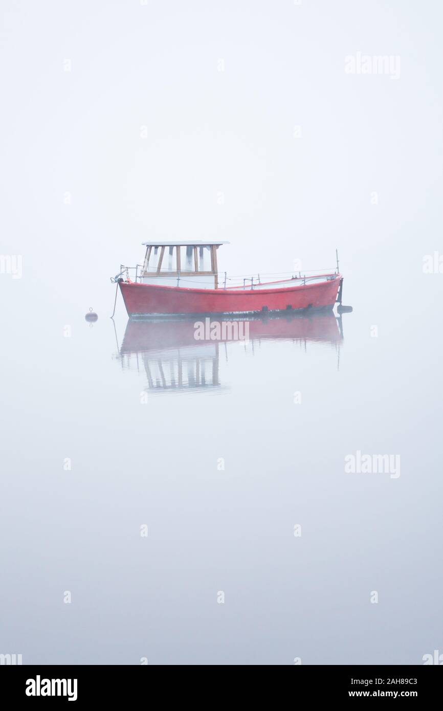 Freizeit Boot im Nebel auf einer frühen Herbst Morgen kurz nach Sonnenaufgang auf dem Coniston Water im Lake District, Cumbria, England. Stockfoto