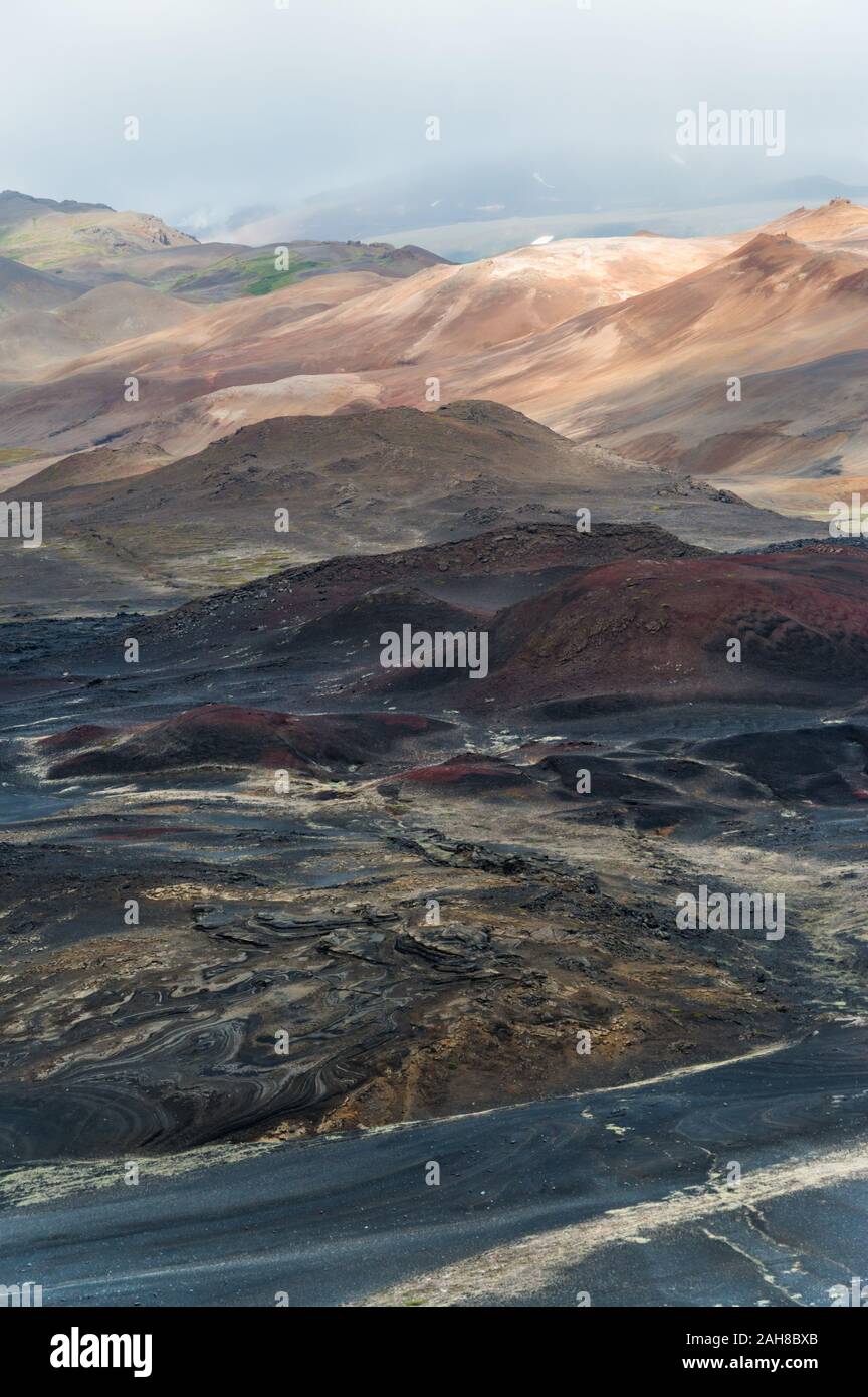Ikonische isländische Wüstenlandschaft mit einer Reihe von farbigen Hügeln, die sich bis zum Horizont erstrecken Stockfoto