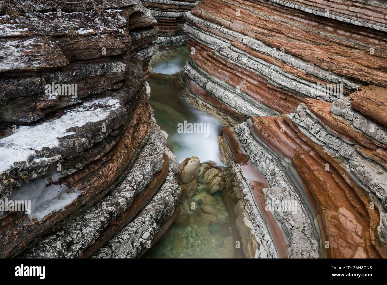Weitwinkelansicht eines schichteten Schlitzschluckes mit einem Bach, der unten fließt Stockfoto