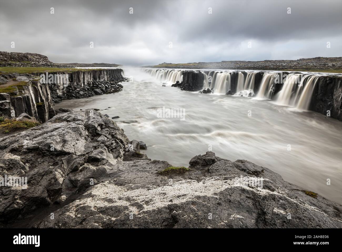 Weitwinkelansicht des isländischen Wasserfalls von Selfoss, unter einem bedrohlichen grauen bewölkten Himmel Stockfoto