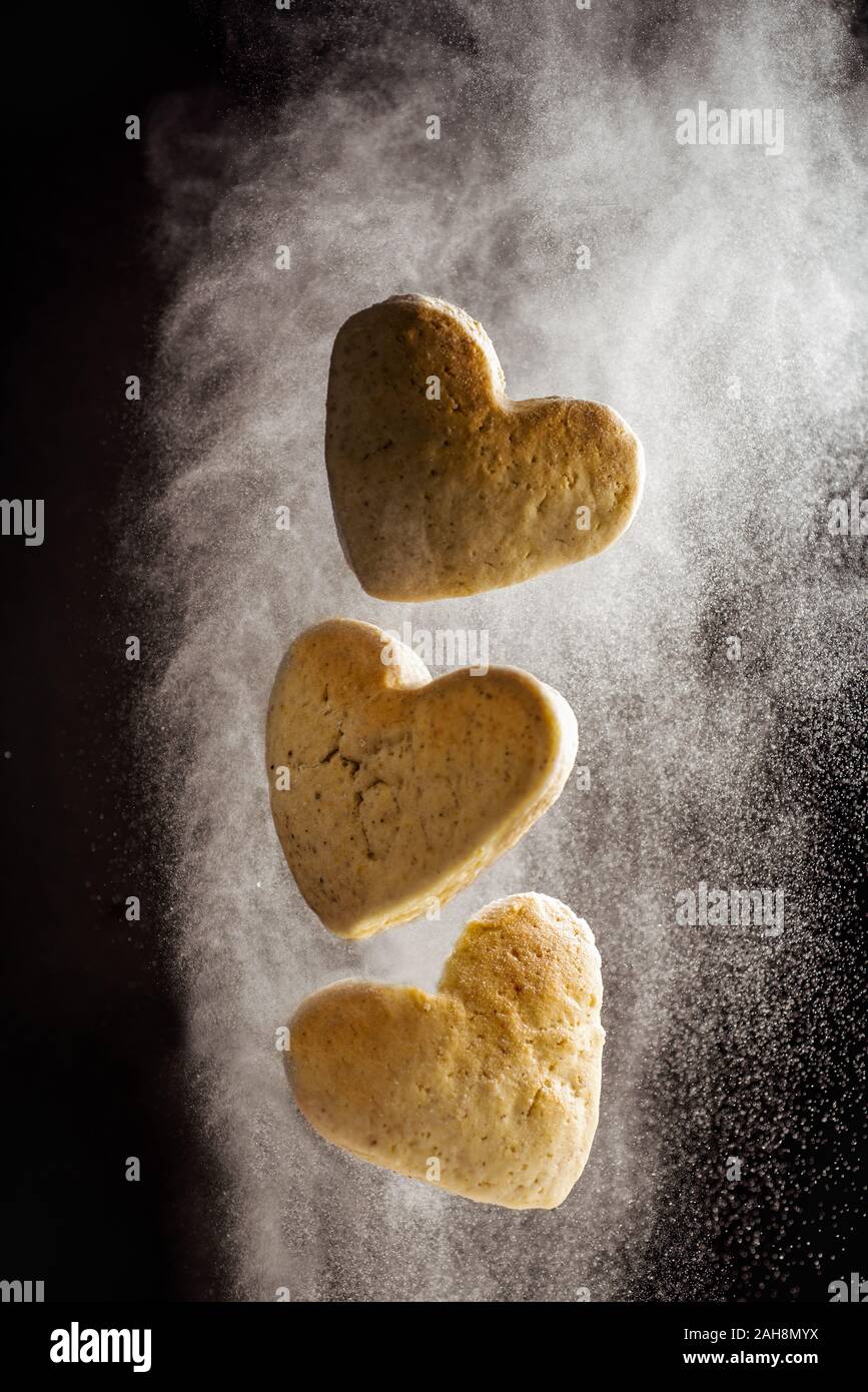 Schweben Herzform cookies Fliegen in Mehl cloud Stockfoto