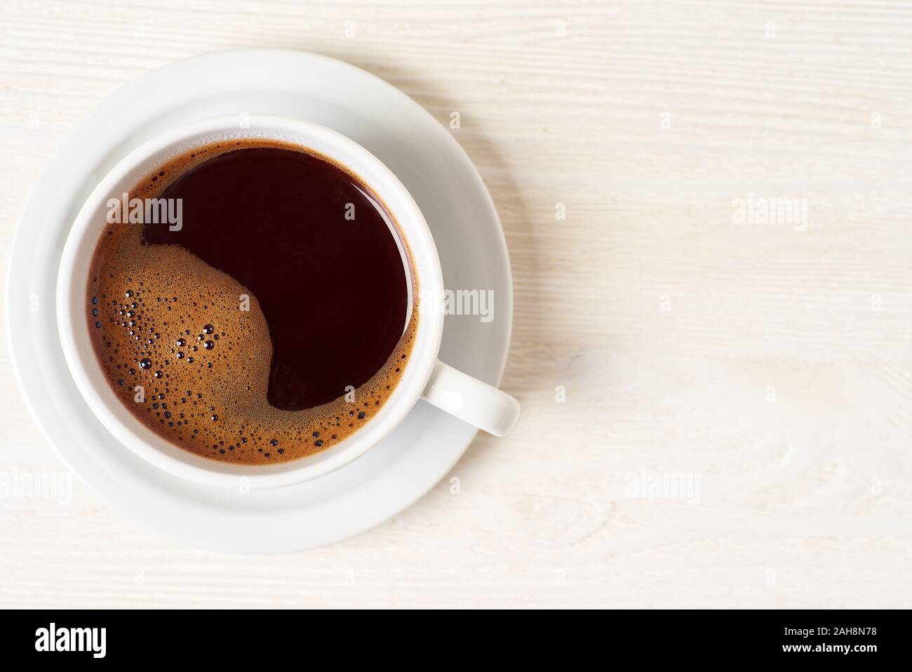 Tasse Kaffee auf weißem Holz- Hintergrund Stockfoto