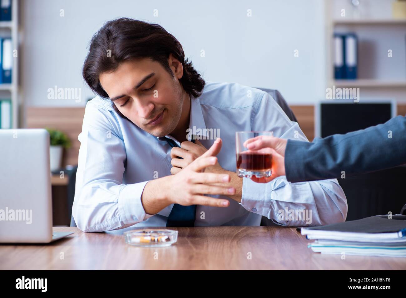 Die männlichen Mitarbeiter, Alkohol zu trinken und Zigaretten zu rauchen an workpla Stockfoto