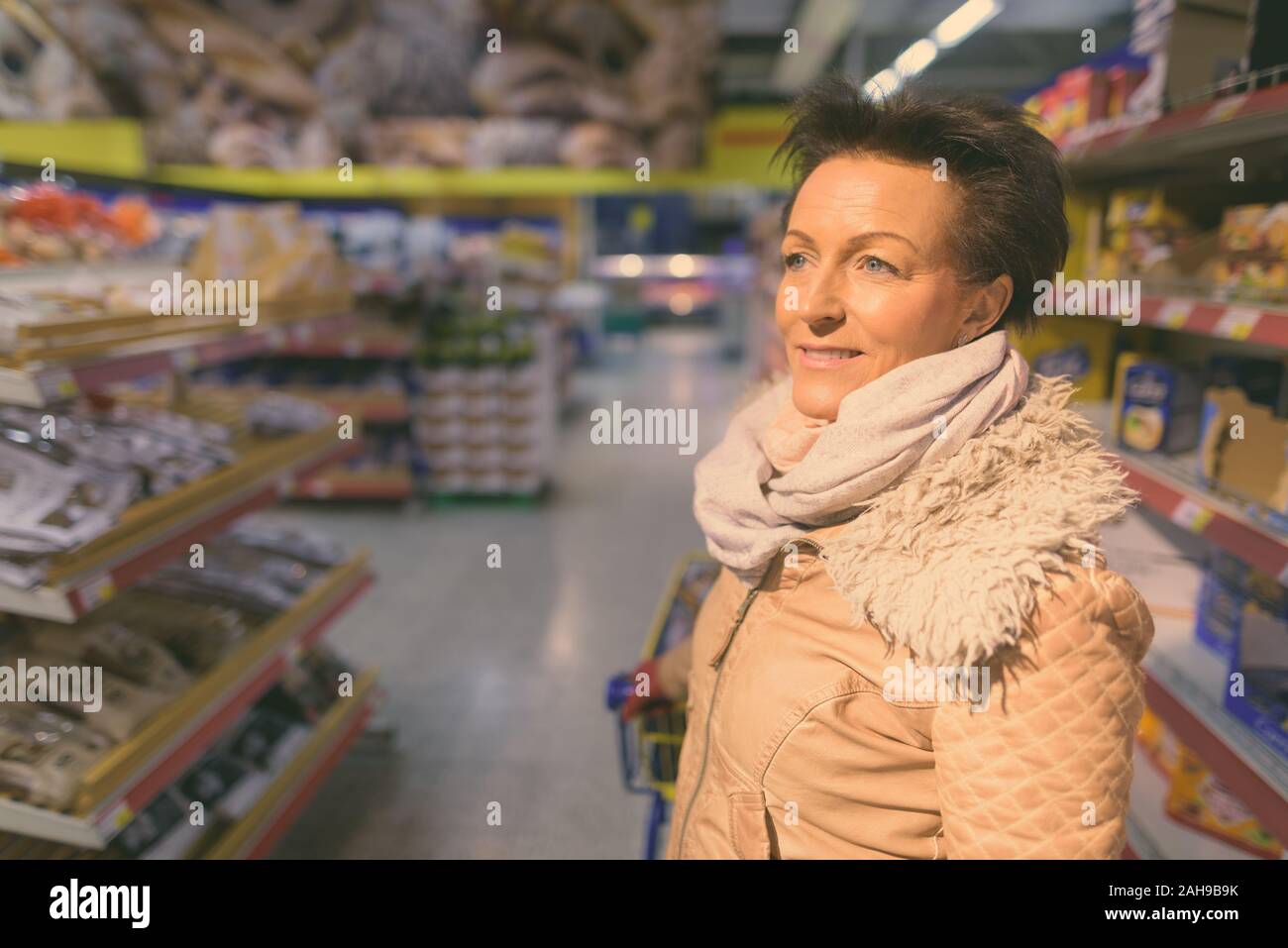 Schöne, reife Frau Einkaufen im Supermarkt Stockfoto