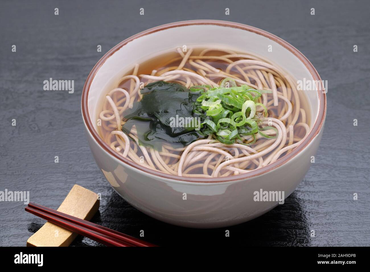 Japanische Kake Soba Nudeln in eine keramische Schüssel auf schwarzem Hintergrund Stockfoto