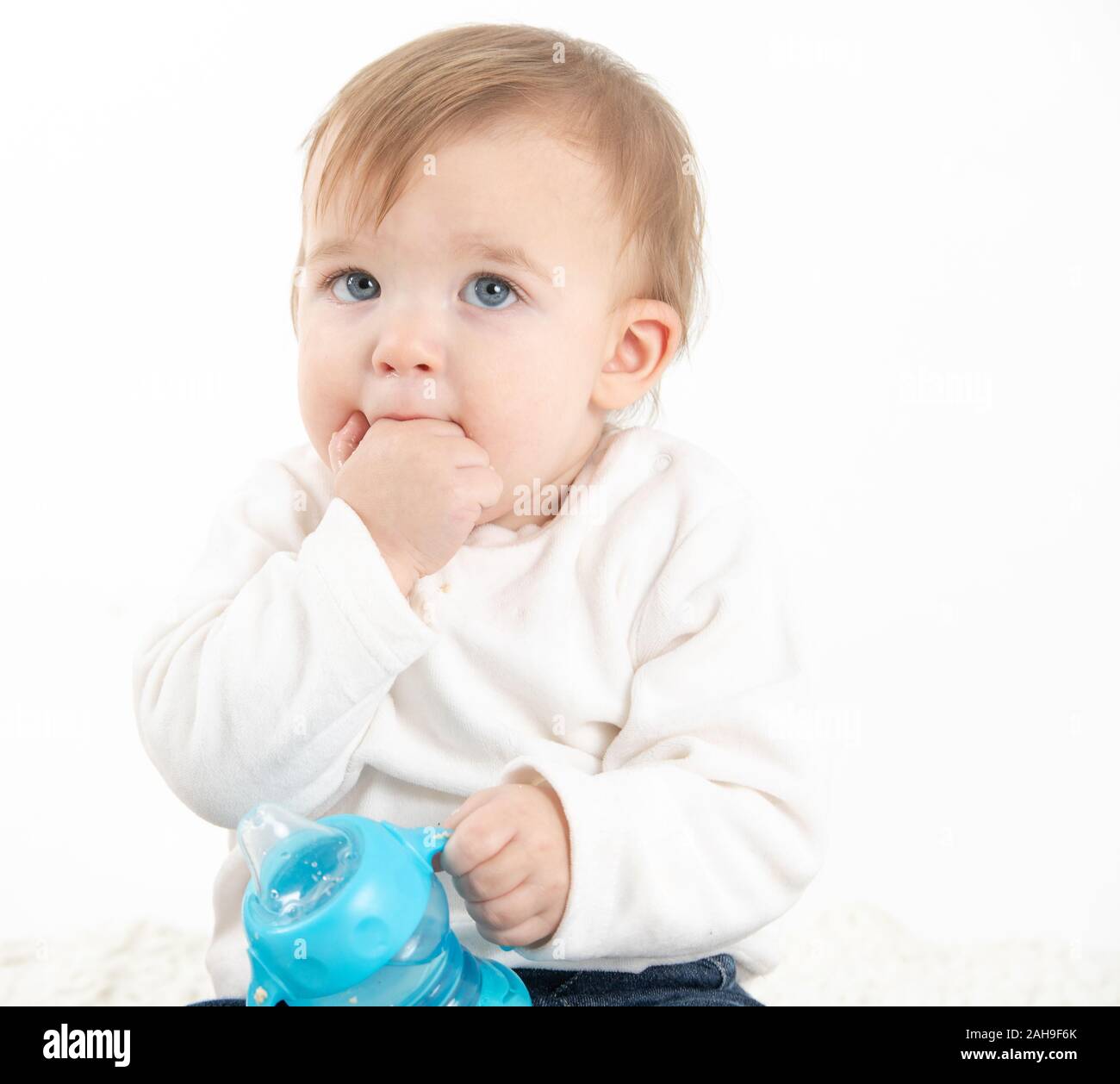 Stock studio Foto mit einem weißen Hintergrund eines Babys mit einer Kantine mit Griffen Stockfoto