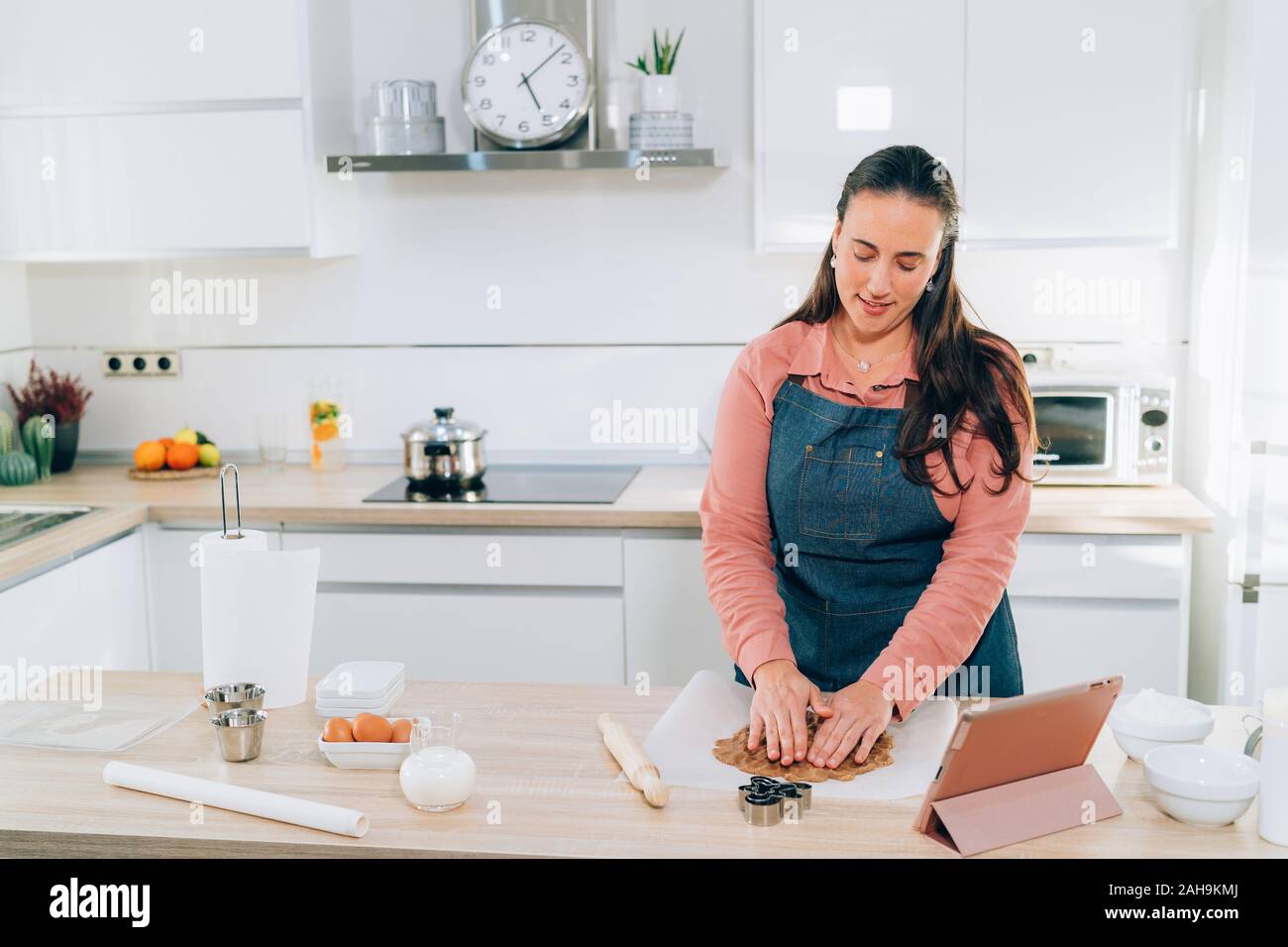 Junge brünette Frau Vorbereitung Weihnachtsplätzchen zu Hause. Handgemachte Lebkuchen Cookies. Stockfoto