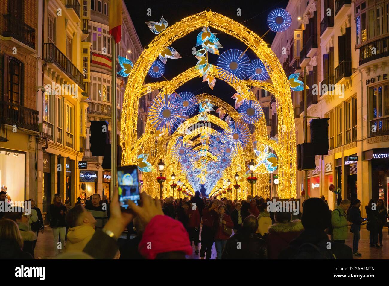 Menschenmassen bewundern Weihnachten Straße leuchtet das Display in der Calle Larios, der Hauptstraße von Malaga, Costa del Sol, Provinz Malaga, Südspanien. Stockfoto