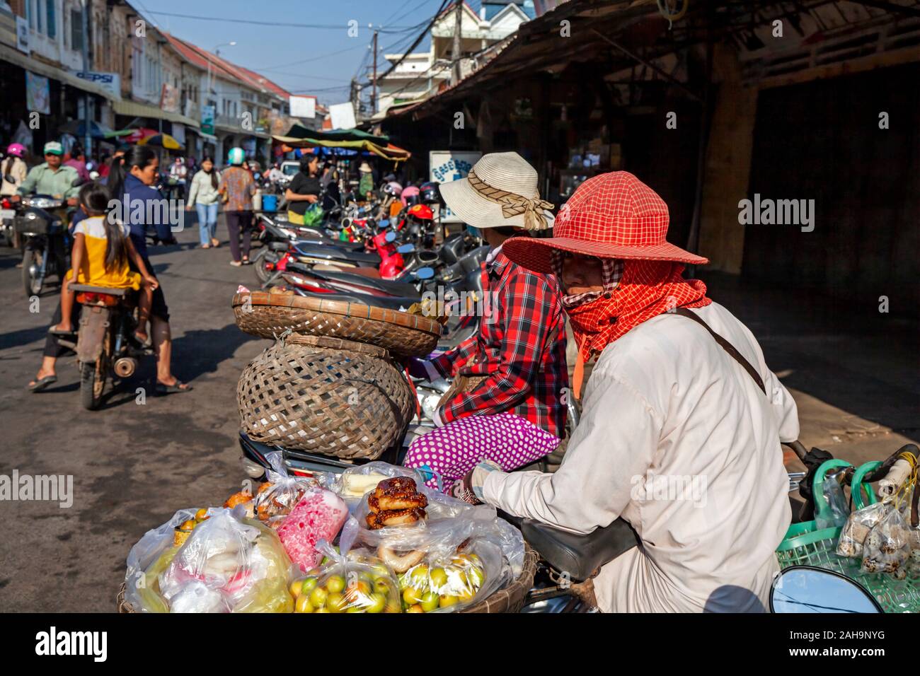 Eine Frau bereitet zu verkaufen Wüste, Obst und Donuts zu Ihrem Fahrrad geschnallt zu einem Straßenmarkt in Kampong Cham, Kambodscha.. Stockfoto