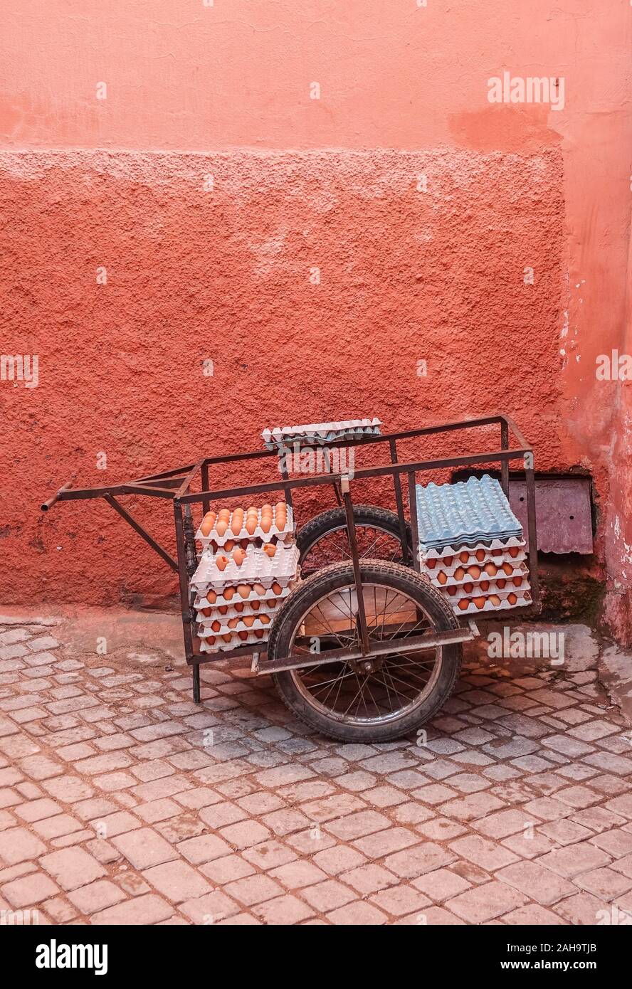 Träger mit Eiern gegen eine Rote Wand in der Mitte der Medina. Marrakesch, Marokko. Stockfoto