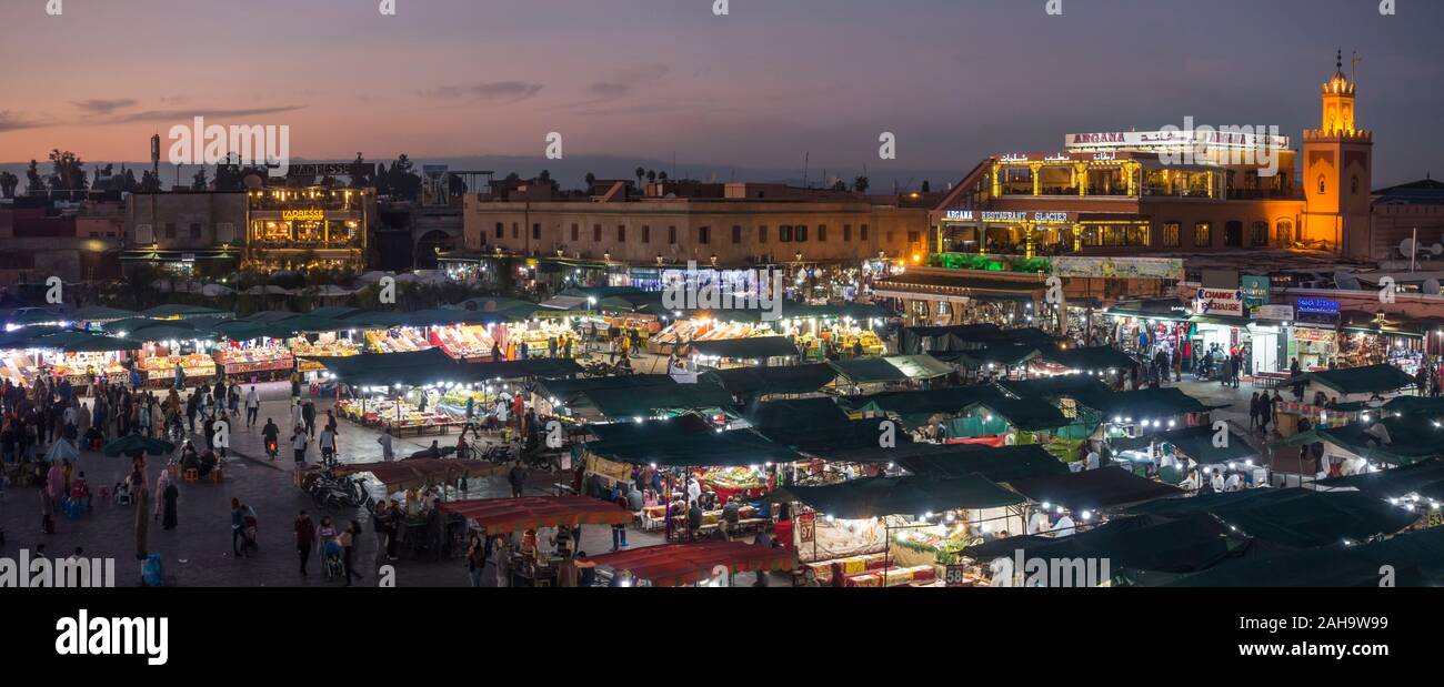 Platz Jemaa el-Fna entfernt. Garküchen und Massen an den Jemaa El Fna Square bei Nacht, Marrakesch, Marokko. Stockfoto