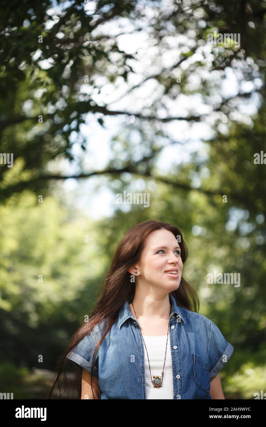 Junge lächelnde brünette Frau Fuß draußen im Park Stockfoto