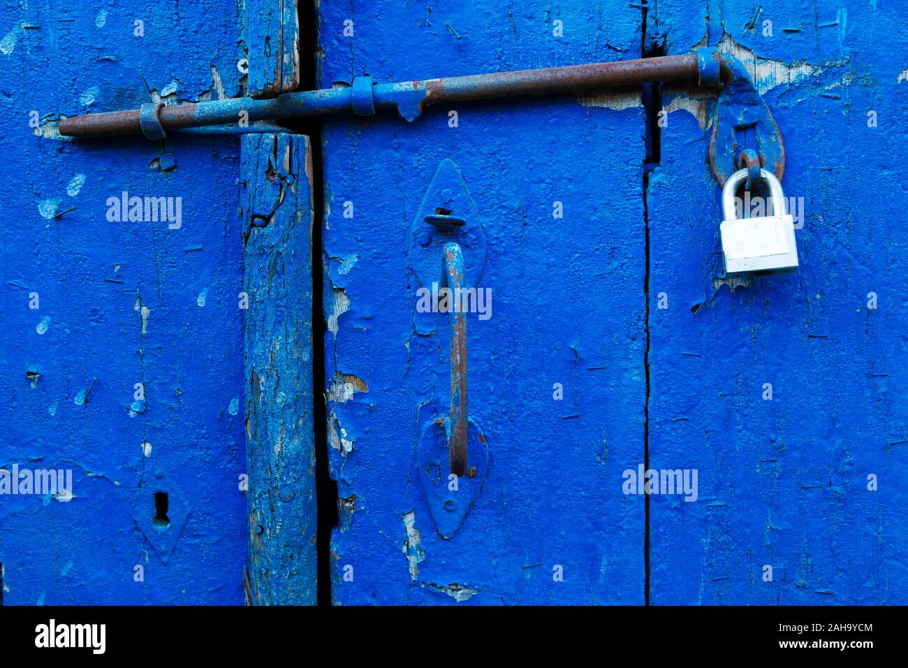 Sperre auf eine Tür in der Altstadt von Limassol auf Zypern. Die blaue Farbe ist gerissen und gechipt. Stockfoto