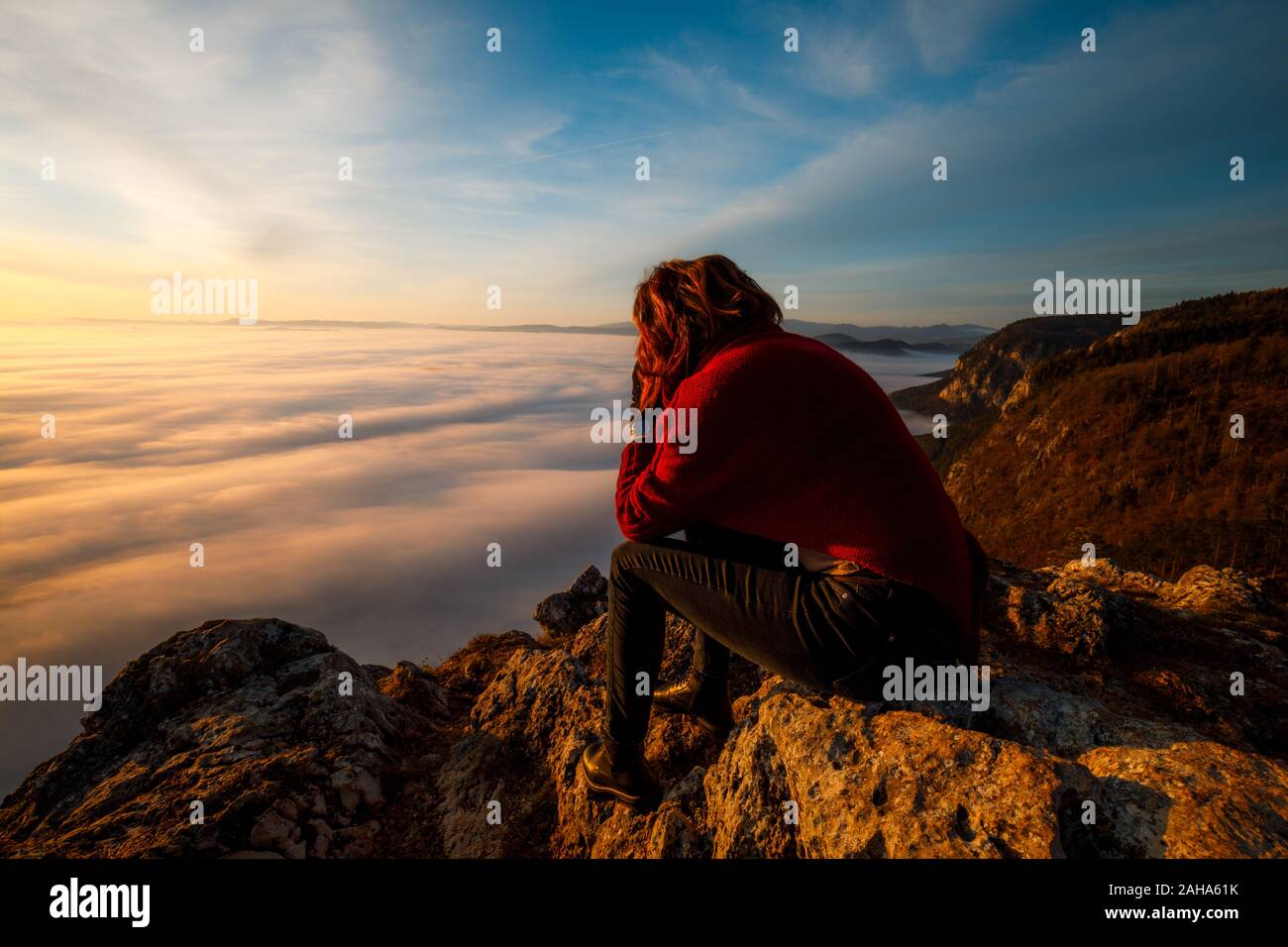 Glückliche Frau Touristen sitzen auf dem Gipfel des Berges und auf der schönen Nebel betrachten. Konzept der Freiheit. Stockfoto
