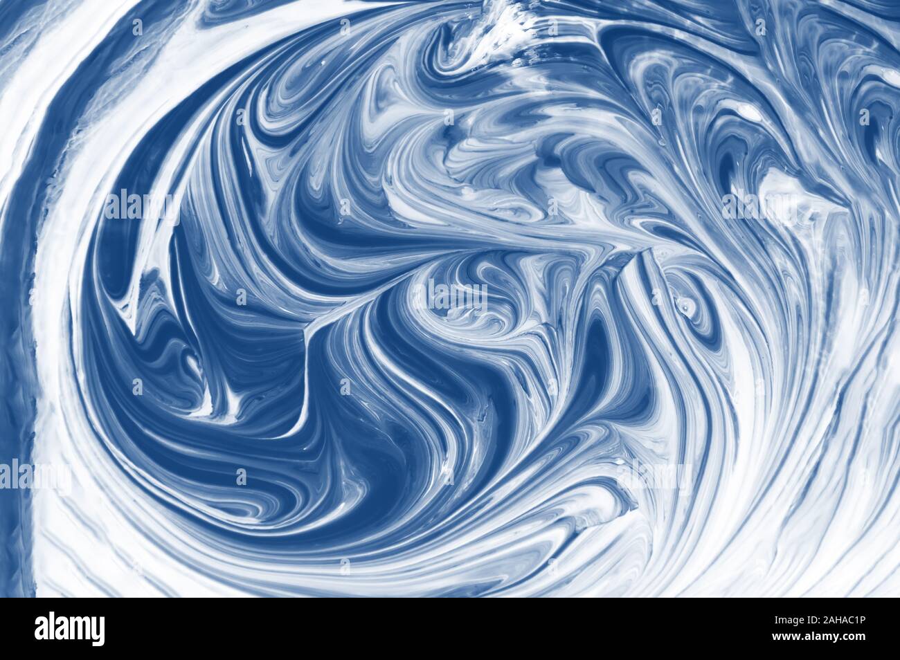 Abstrakt Blau und weiße Flüssigkeit Hintergrund mit Wirbel und Wellen Muster. Gemischte flüssige Acrylfarbe getönten in trendigen Classic blau Farbe des Jahres 2020 Stockfoto