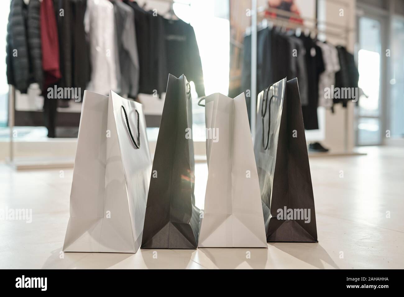 Reihe von Schwarzen und Weißen paperbags stehend auf dem Boden der Boutique Stockfoto