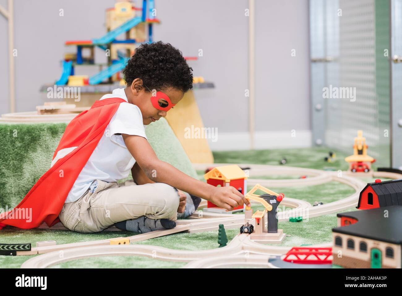 Cute little boy das Tragen der roten Mantel von Superman spielen im Kindergarten Stockfoto