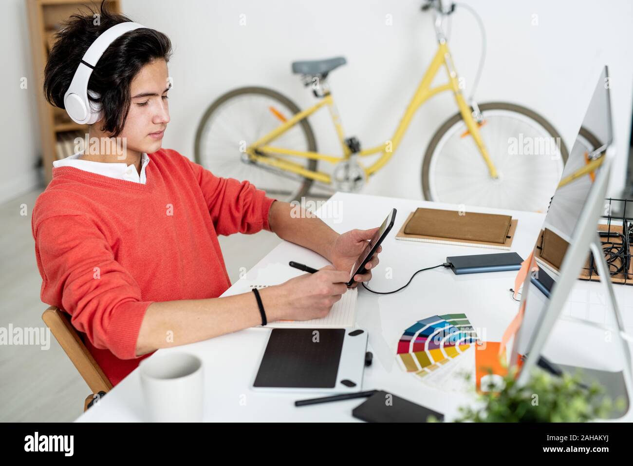 Ernsthafte Kerl auf der Suche nach Bildschirm des Smartphones beim Blättern und Auswählen logo Stockfoto