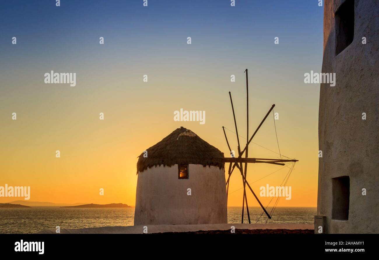 Das Symbol von Mykonos: Seascape bei Sonnenuntergang mit weißen berühmten Windmühlen, Kykladen, Griechenland. Stockfoto