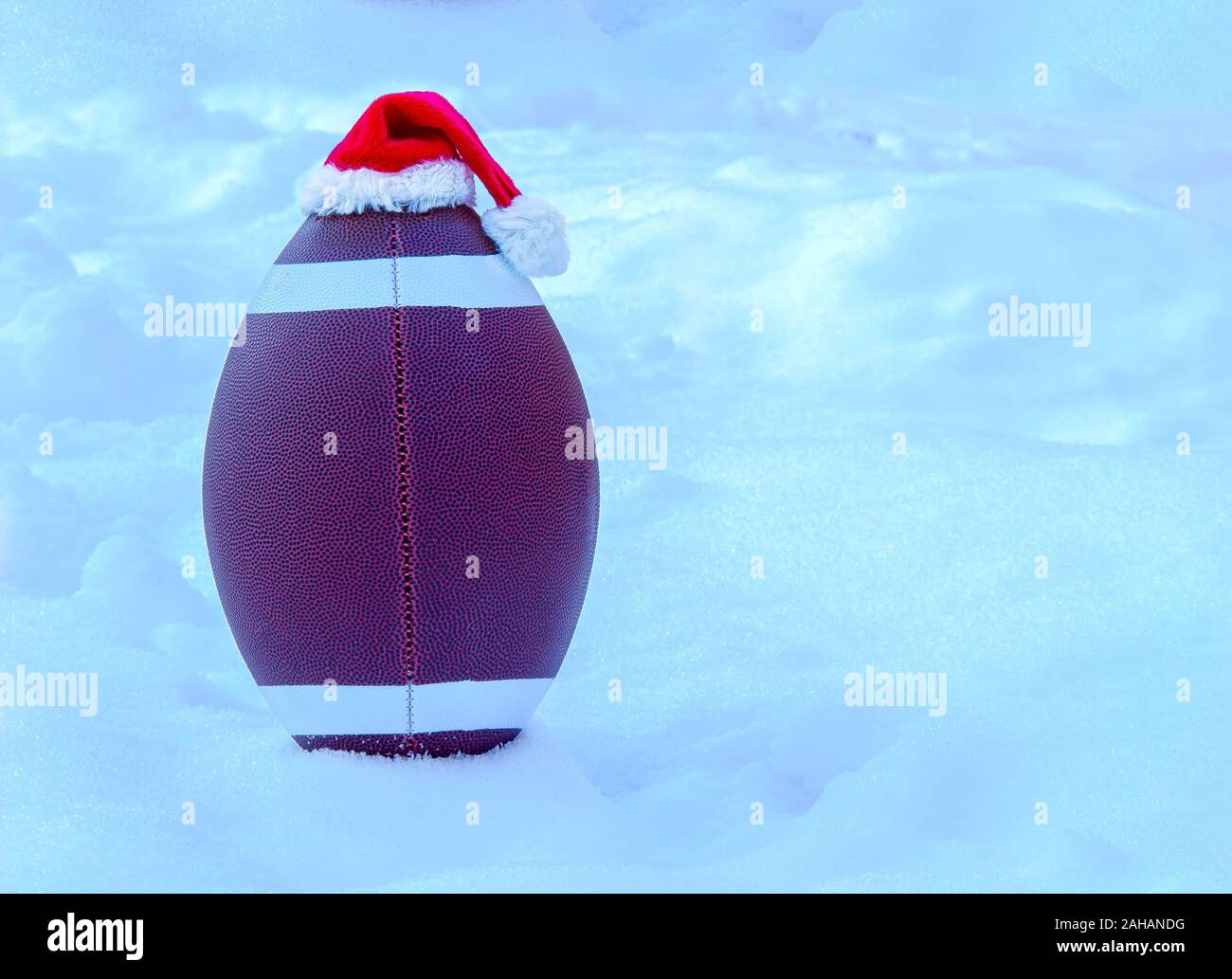 American Football das Tragen eines Santa Claus hat auf Schnee Stockfoto