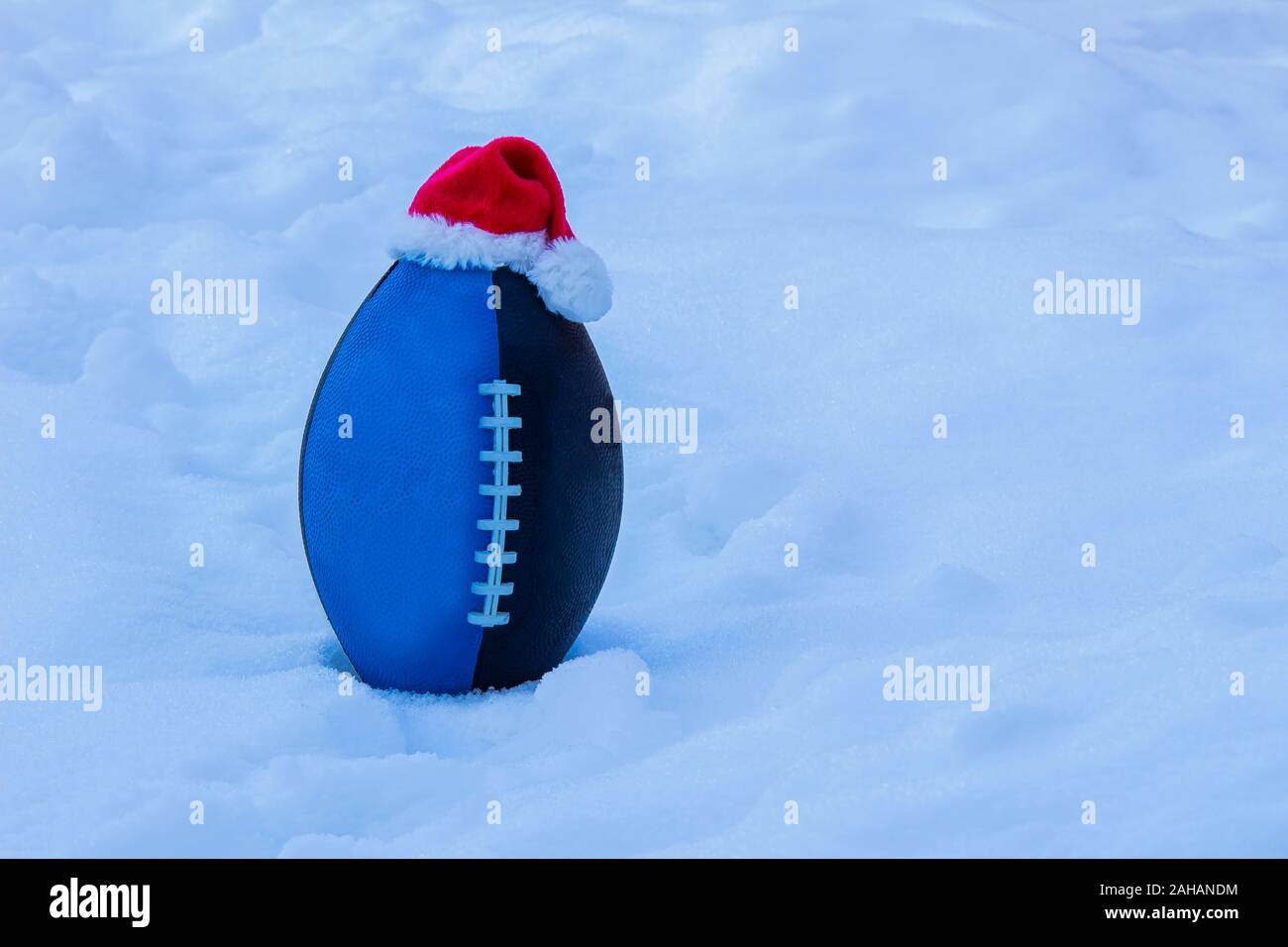Blau Schwarz Junior Football tragen ein Weihnachtsmann hat auf Schnee Stockfoto