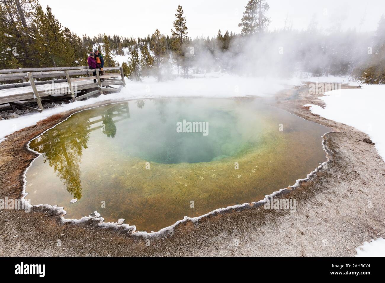 Touristen die Morning Glory Pool im Upper Geyser Basin im Winter im Yellowstone Nationalpark Yellowstone, Wyoming. Yellowstone ist Heimat für die Hälfte der Welten Gesamtzahl der Geysire, mit Tausenden von heißen Quellen, und etwa 300 bis 500 Geysire. Stockfoto