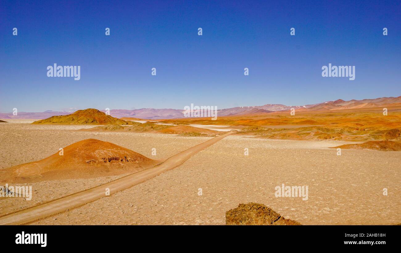 Red 4WD-Tracks in einem Salzsee von rot und orange Hügeln unterbrochen Schnitt, in der höhenlage Altiplano puna Wüste in der Nähe von Salta in Argentinien Stockfoto