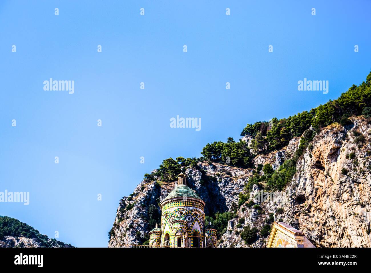 Amalfi City minimalistischer Blick auf die Kirche grünen Kuppel Dach mit Fliesen Muster und Felsen Klippen Berge. Amalfitana. Stockfoto